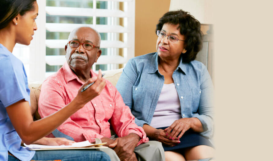 caregiver discussing care plan to an elderly couple