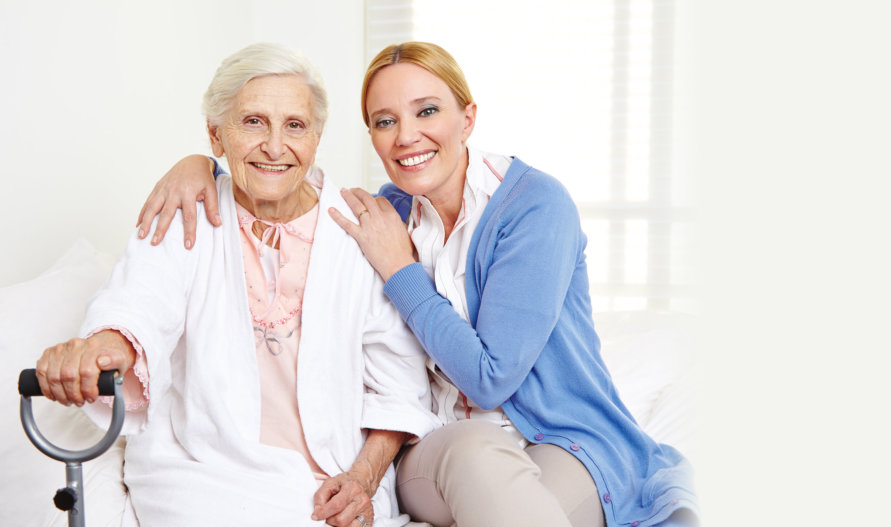 portrait of a smiling caregiver and her old patient