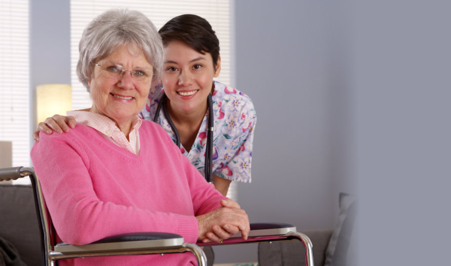 portrait of a smiling caregiver and her old patient